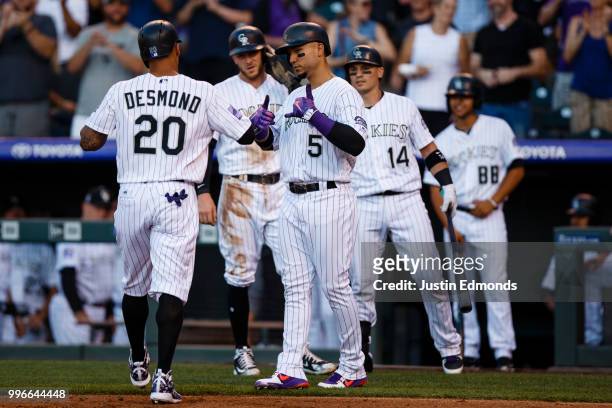 Ian Desmond of the Colorado Rockies is congratulated by Carlos Gonzalez, Trevor Story and Tony Wolters after hitting a two-run home run in the first...