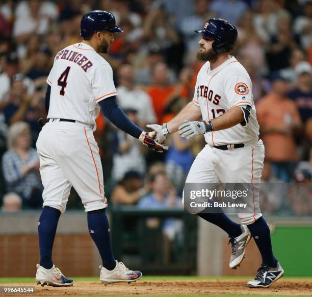 Tyler White of the Houston Astros receives congratulations from George Springer after hitting a home run in the fifth inning against the Oakland...