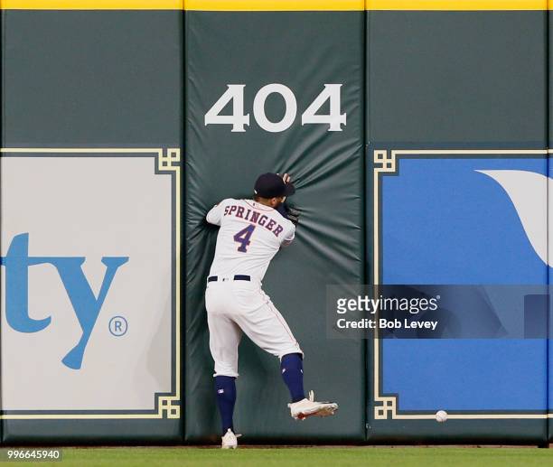 George Springer of the Houston Astros slams into the wall as he attempts to catch a line drive from Khris Davis of the Oakland Athletics in the sixth...