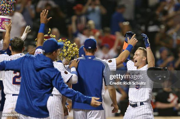 Brandon Nimmo of the New York Mets is greeted at home plate after hitting a pinch-hit, walk-off home run in the 10th inning against the Philadelphia...