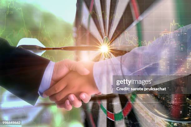 double exposure of   businessman groups handshake for business and darts arrow. - man double exposure profit concept stock pictures, royalty-free photos & images