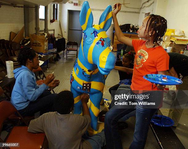 Sixth grader Rickeya McClain paints a "Party Animal" donkey that will be one of 200 sculptures soon to adorn the streets of Washington DC, in a...