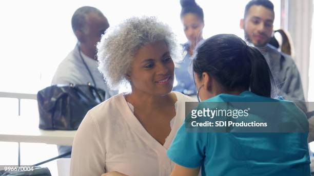 femme senior bénéficie d’examen médical gratuit - table dexamen médical photos et images de collection