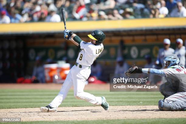 Jed Lowrie of the Oakland Athletics hits a double during the game against the Los Angeles Angels of Anaheim at the Oakland Alameda Coliseum on June...