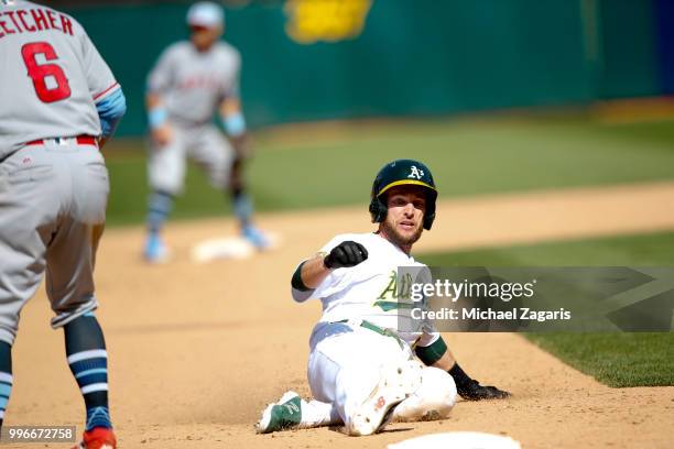 Jed Lowrie of the Oakland Athletics slides safely into third during the game against the Los Angeles Angels of Anaheim at the Oakland Alameda...