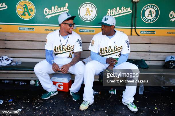 Frankie Montas and Santiago Casilla of the Oakland Athletics talk in the dugout during the game against the Los Angeles Angels of Anaheim at the...