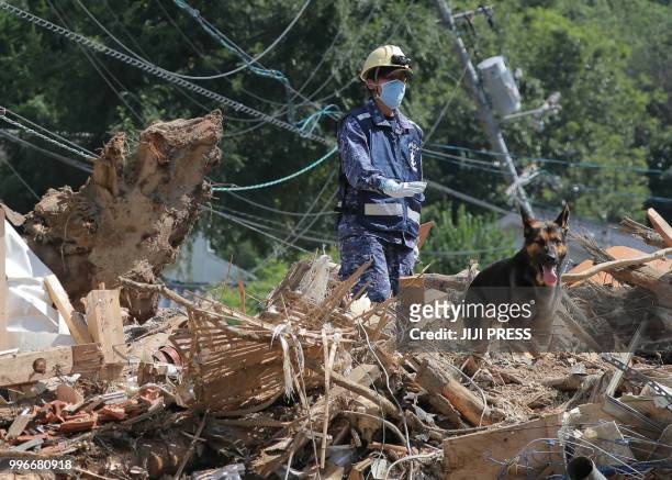 Member of Maritime Self Defense Forces searches for missing persons at a flood damage site in Kure, Hiroshima prefecture on July 12, 2018. - The toll...