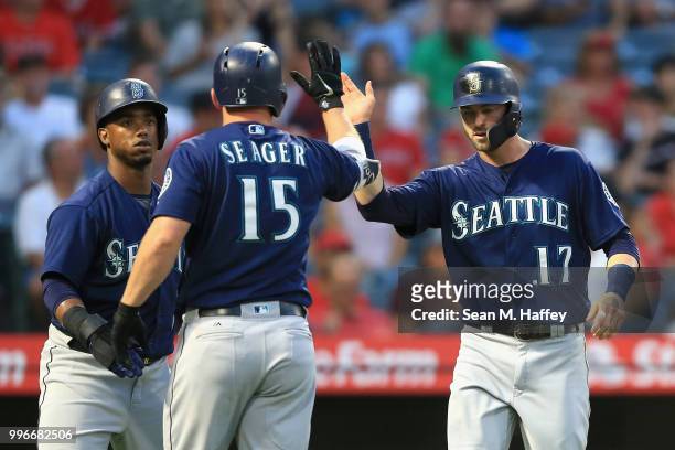 Kyle Seager and Jean Segura congratulate Mitch Haniger after he scored on a two-run RBI hit by Nelson Cruz of the Seattle Mariners during the fourth...