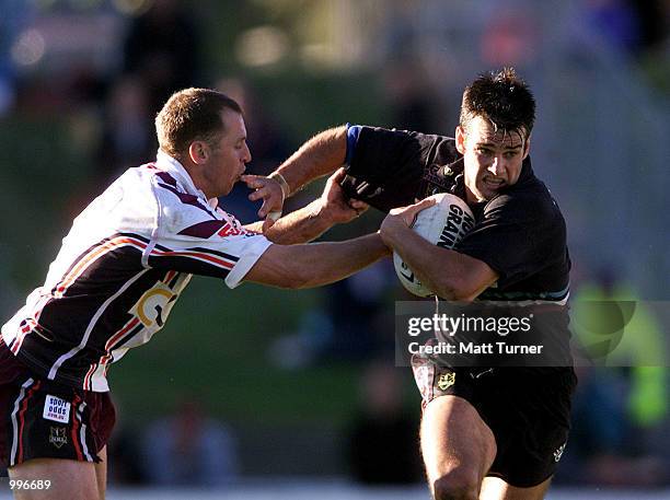Ryan Girdler of the Panthers gets tackled by Brendon Reeves of the Eagles during the NRL round 16 match between the Northern Eagles and the Penrith...