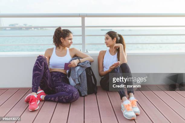 women sitting on a jogging break - zoranm imagens e fotografias de stock