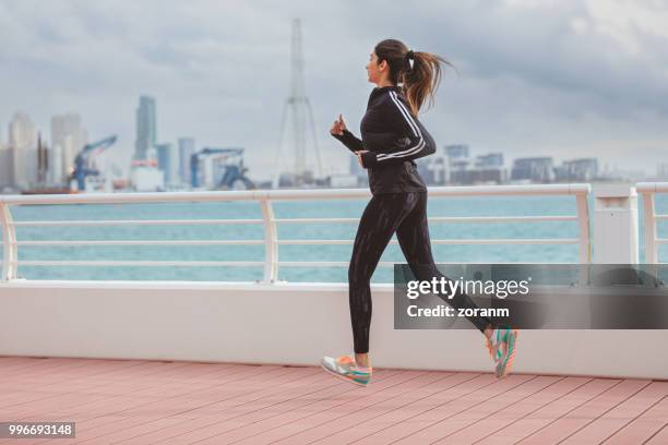 side view jogging mid-air - zoranm imagens e fotografias de stock