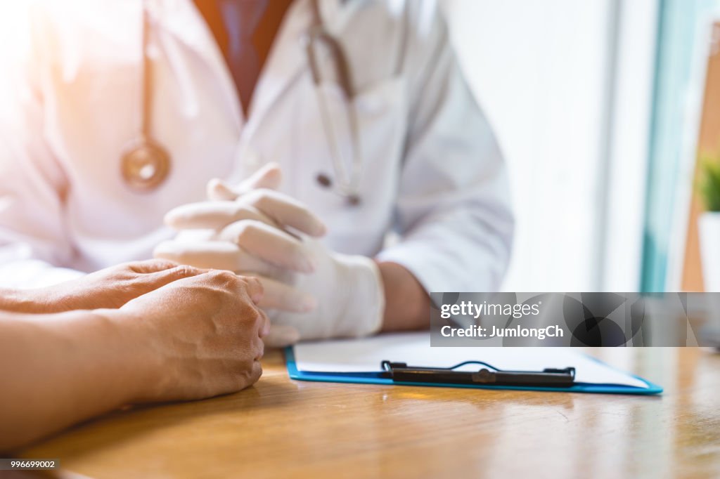 En läkare arbetar på sjukhuset, han är klädd i en brun stetoskop och han undersöker sjukan av patienten.