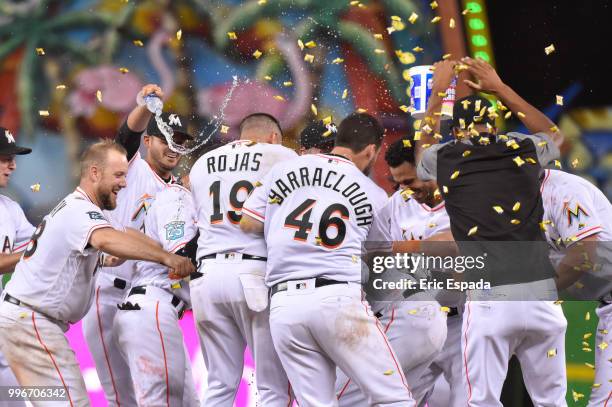 Miami Marlins players congratulate Starlin Castro after he hit a walk off single in the twelfth inning against the Milwaukee Brewers at Marlins Park...