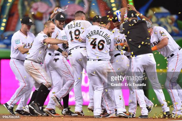 Miami Marlins players congratulate Starlin Castro after he hit a walk off single in the twelfth inning against the Milwaukee Brewers at Marlins Park...