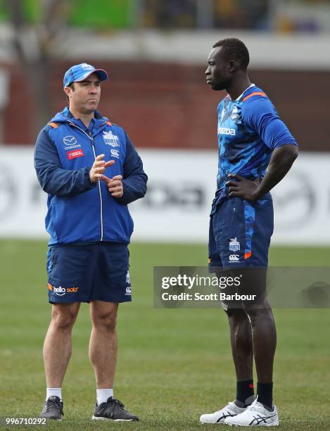 Brad Scott, coach of the Kangaroos talks to Majak Daw of the Kangaroos during a North Melbourne Kangaroos Training Session on July 12, 2018 in...