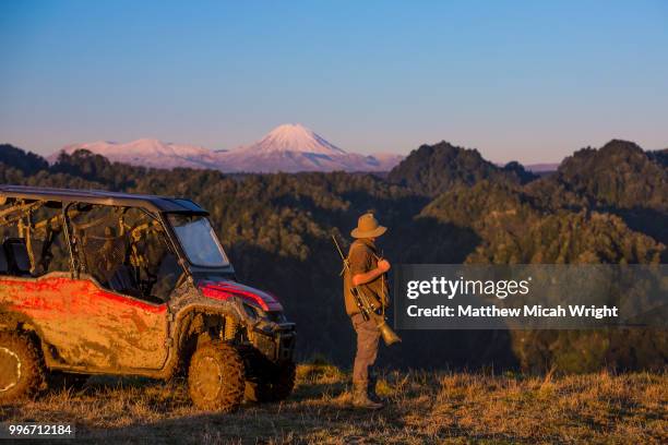 the blue duck lodge located in the whanganui national park is a working cattle farm with a focus on conservation. a man watches the sun set over mount doom (mount ngauruhoe) and the tongariro crossing. - tongariro crossing stock pictures, royalty-free photos & images