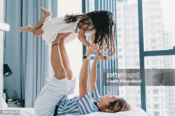 mãe e filha tocando juntos na cama - chinese mothers day - fotografias e filmes do acervo