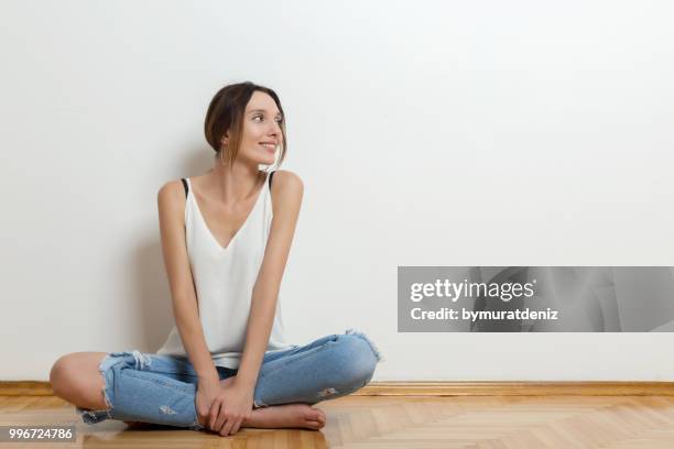 mujer sentada en el suelo - sitting on floor fotografías e imágenes de stock