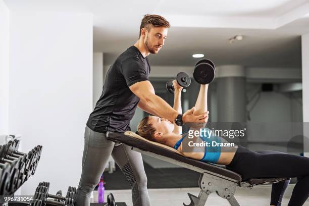 personal trainer with female trainee in gym - drazen stock pictures, royalty-free photos & images