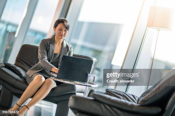 businesswoman using laptop at airport - technophile stock pictures, royalty-free photos & images