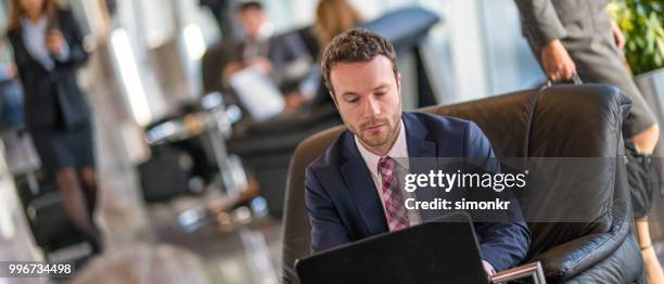businessman using laptop at airport - technophile stock pictures, royalty-free photos & images