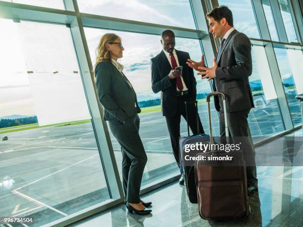 business people standing at airport departure area - technophile stock pictures, royalty-free photos & images