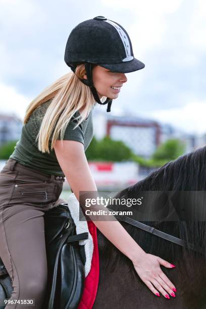 smiling woman riding a horse - zoranm imagens e fotografias de stock