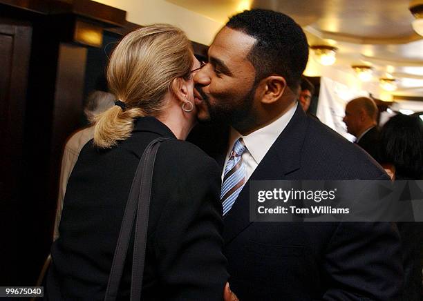 Jerome Bettis of the Pittsburgh Steelers, kisses Kellie Johnson of GlaxoSmithKline, after a news conference held by the U.S. Surgeon General and the...