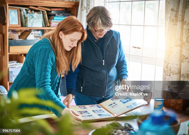 oma en kleindochter kijken naar familie fotoalbum - cephalon climbs above valeant takeover bid of 73 a share stockfoto's en -beelden