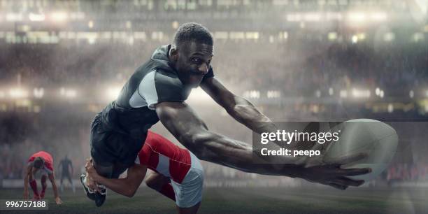 tackled rugby player in mid air about to score try - rugby try stock pictures, royalty-free photos & images