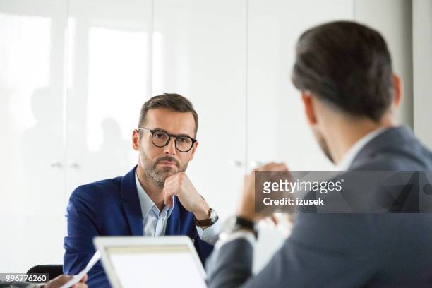 mature businessman in meeting with colleagues - izusek stock pictures, royalty-free photos & images