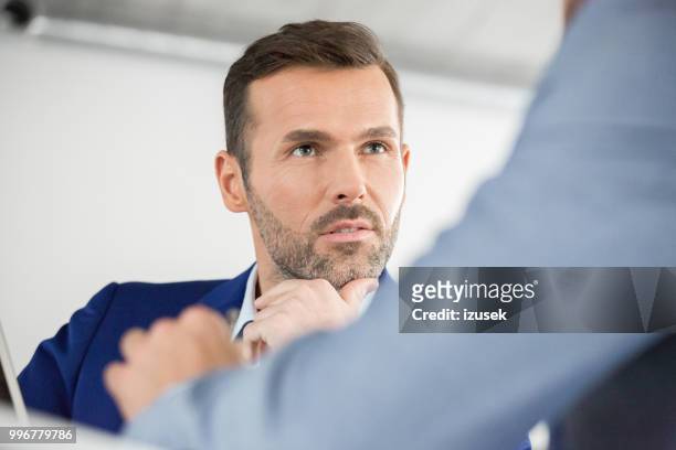 mature businessman during meeting in office - izusek stock pictures, royalty-free photos & images