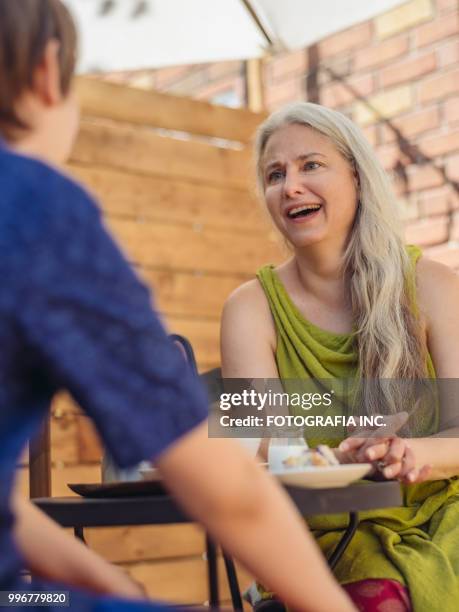 patio time with moter and son - shade45 stock pictures, royalty-free photos & images