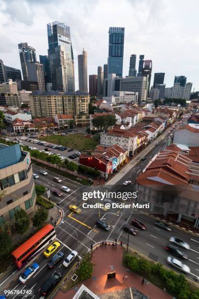 high angle view of an intersection in singapore chinatown with its traditional architecture and the skyscraper of the financial district in the background - didier marti stock pictures, royalty-free photos & images
