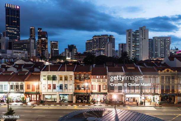 twilight over singapore chinatown with its traditional  townhouses with office towers and apartment block in singapore - didier marti stock pictures, royalty-free photos & images
