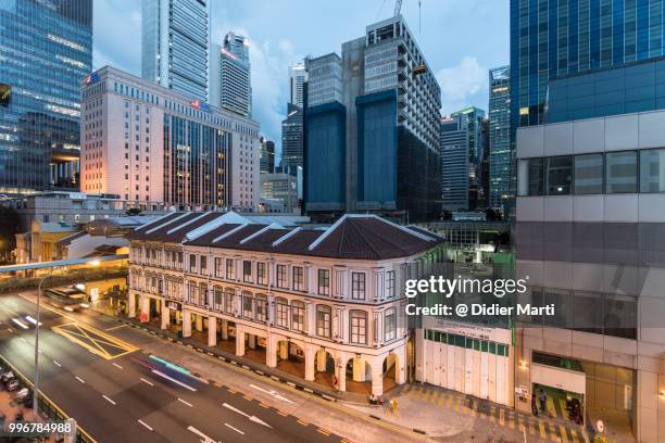 contrast between singapore business and financial district and traditional town houses in chinatwon at dusk - didier marti stock pictures, royalty-free photos & images