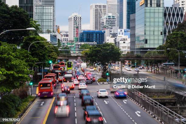 traffic, captured with blurred motion, rushing in the street of singapore downtown district in singapore - road signal 個照片及圖片檔