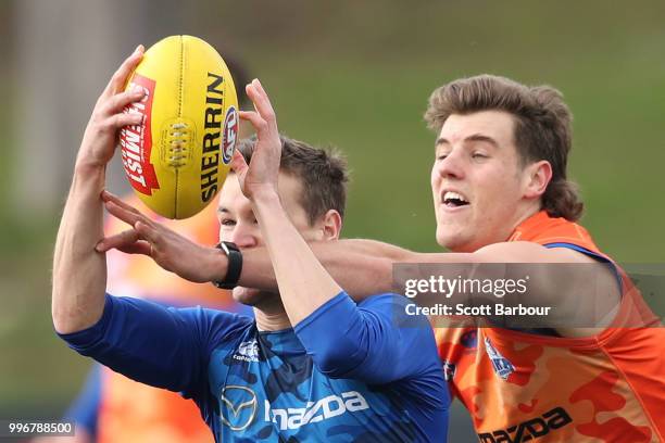 Kayne Turner of the Kangaroos and Declan Watson of the Kangaroos compete for the ball during a North Melbourne Kangaroos Training Session on July 12,...