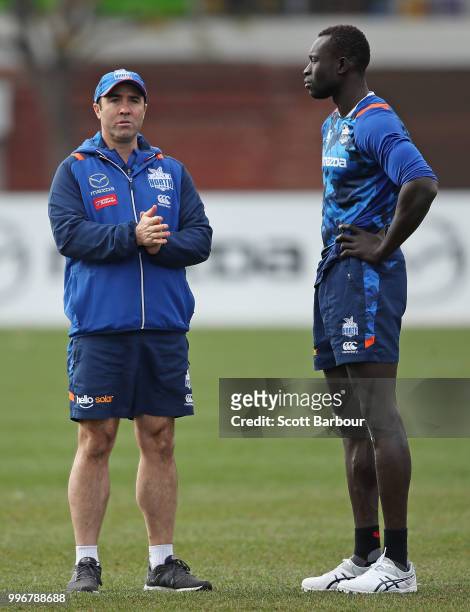 Brad Scott, coach of the Kangaroos talks to Majak Daw of the Kangaroos during a North Melbourne Kangaroos Training Session on July 12, 2018 in...