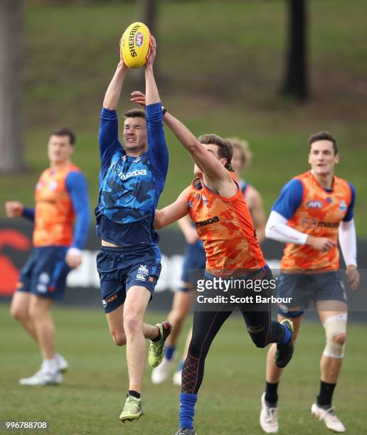 Kayne Turner of the Kangaroos and Declan Watson of the Kangaroos compete for the ball during a North Melbourne Kangaroos Training Session on July 12,...