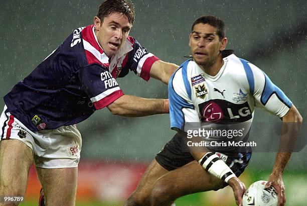 David Peachey of the Sharks looks to offload under pressure from Brad Fittler of the Roosters during the round 21 NRL match between the Sydney...