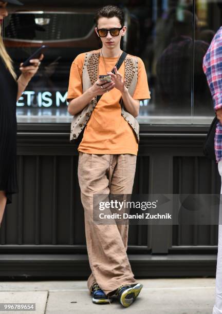Guest is seen wearing an orange shirt, brown pants, brown studded vest and sunglasses outside the Death to Tennis show during the 2018 New York City...