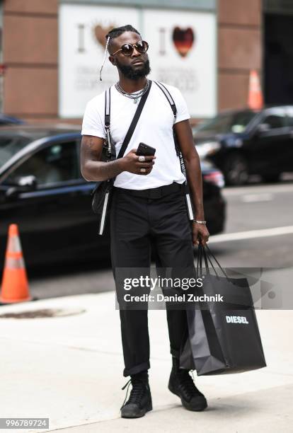 Guest is seen wearing a white shirt and black pants outside the Death to Tennis show during the 2018 New York City Men's Fashion Week on July 11,...