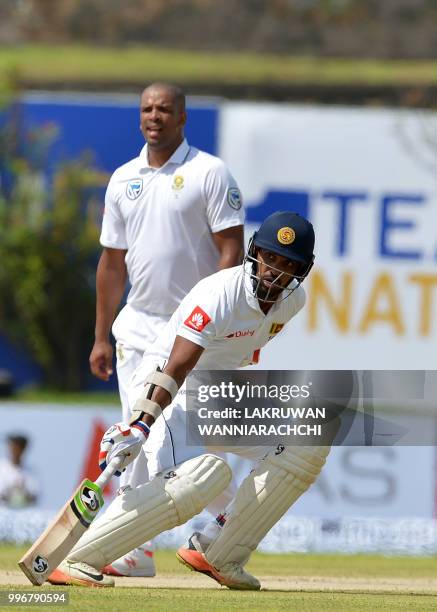 Sri Lankan cricketer Danushka Gunathilaka runs between the wickets as South African cricketer Vernon Philander look on during the first day of their...