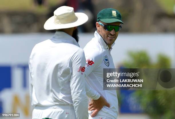 South African cricket team captain Faf du Plessis speaks with teammate Hashim Amla during the first day of their opening Test match between Sri Lanka...