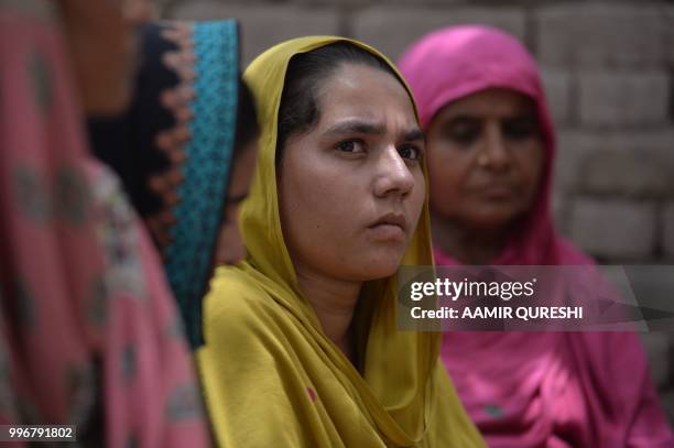 In this picture taken on July 7 Pakistani villagers, who never voted in past general elections, listen to a Pakistani social worker and member of...