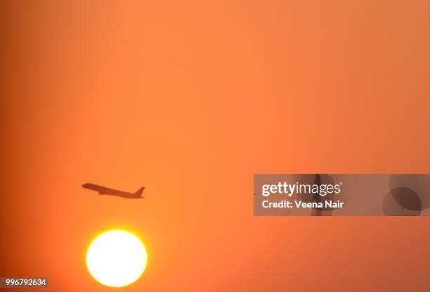 air plane passing through while the sun rises/ahmedabad - veena stock pictures, royalty-free photos & images