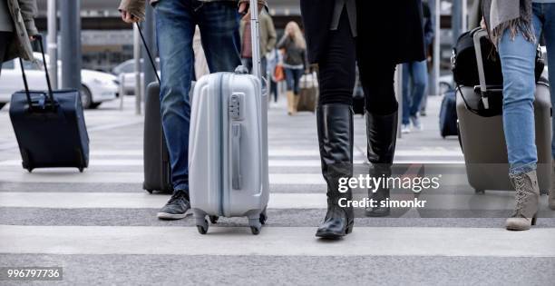 gens d’affaires à pied avec bagages à roues - knee length photos et images de collection