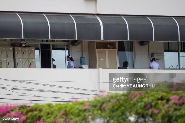 Nurses work along an outside corridor of the hospital where 12 boys and their coach rescued from a Thai cave recover in quarantine, in Chiang Rai on...