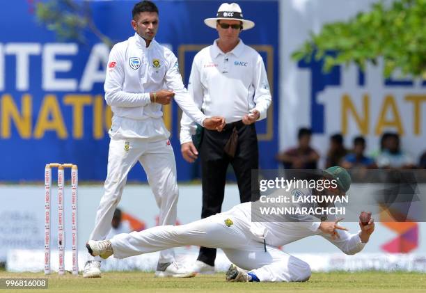 South Africa's Dean Elgar dives as he attempts to field a ball hit by Sri Lanka's Dhananjaya de Silva during the first day of the opening Test match...